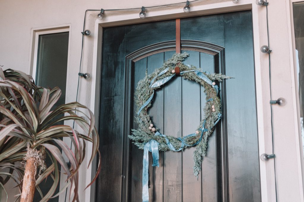 This indigo shibori wreath DIY wreath is a simple touch of greenery and holidays to your door with a pop of color that is very on trend.
