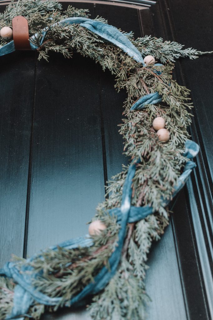 This indigo shibori wreath DIY wreath is a simple touch of greenery and holidays to your door with a pop of color that is very on trend.